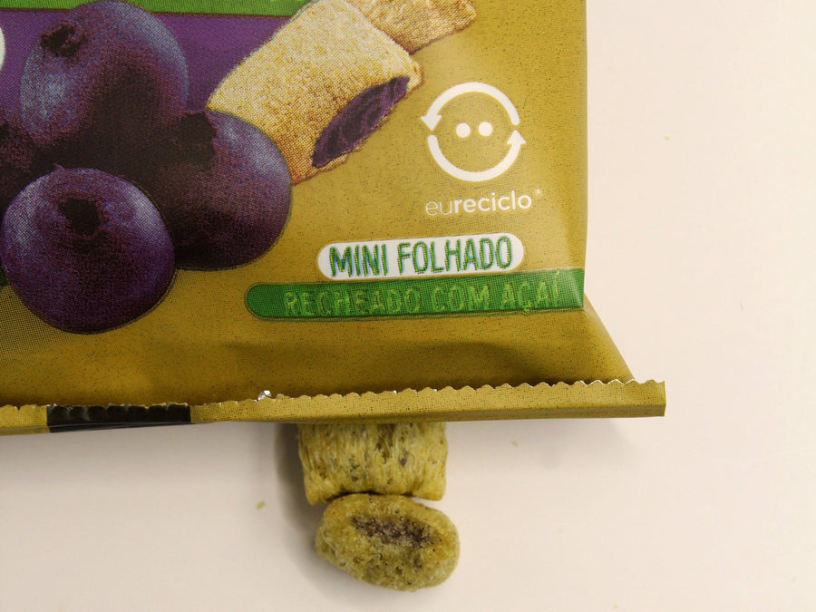 Snack de quinua recheado com açaí saindo do pacote, com o recheio à mostra